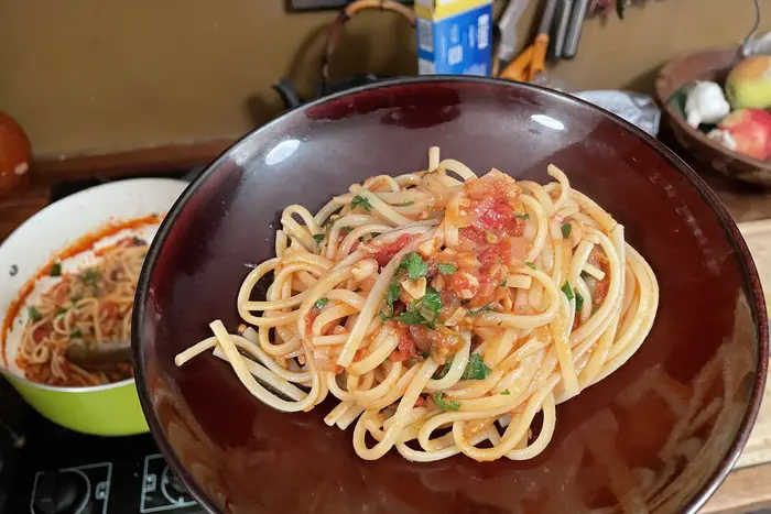 A photo of a portion of spicy clam pasta on a plate.